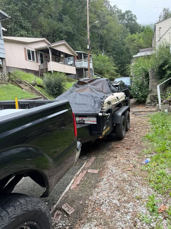 Appalachian Outdoor Services pickup and loaded junk removal trailer on a Logan property
